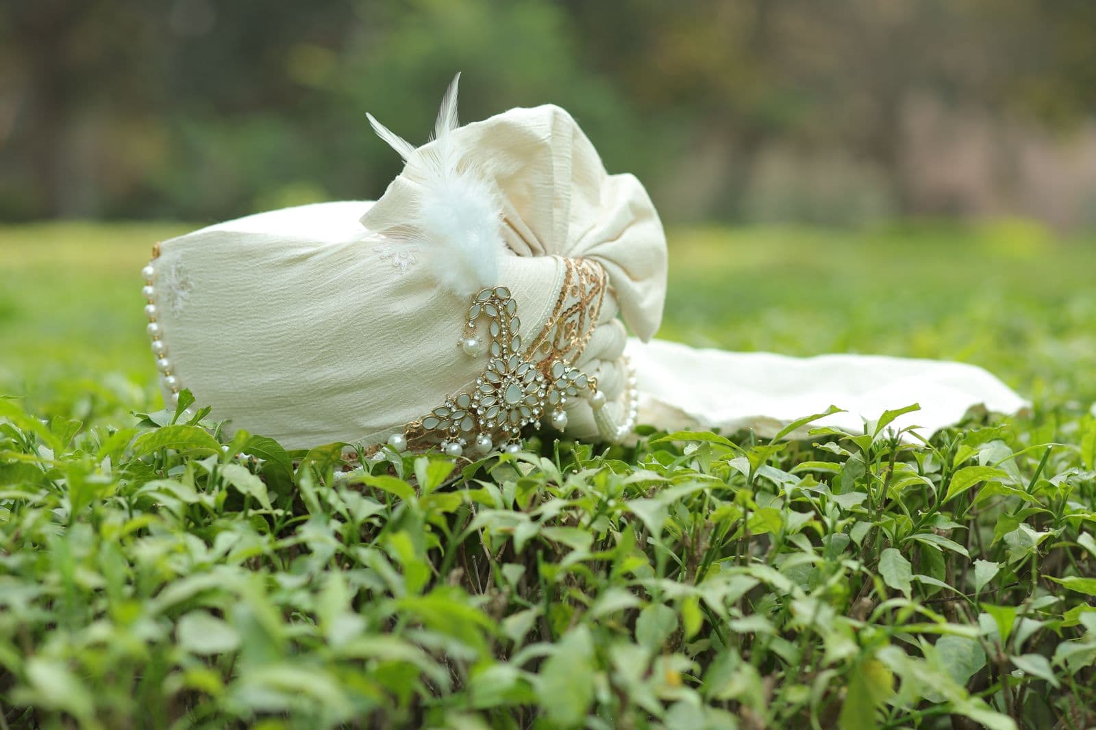 Groom turban sehra with jewelled brooch on green grass